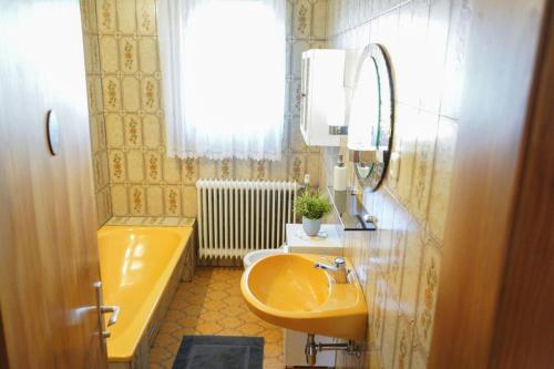 Purgstall赫姆贝戈公寓的浴室配有黄色水槽和浴缸。