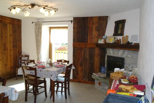 圣皮埃尔B&B Lo VAN - Camere al Verde Villaggio di Rumiod的一间带桌子和壁炉的用餐室