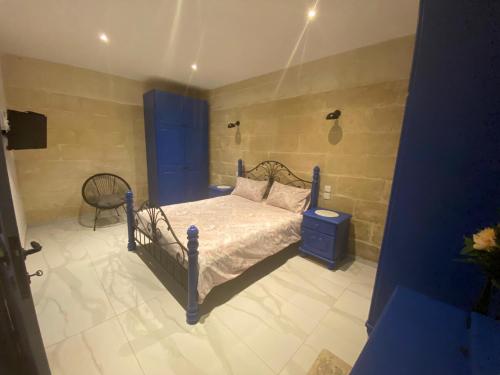 森格莱阿Cosy private townhouse in heart of Senglea的一间卧室配有一张床和一把椅子