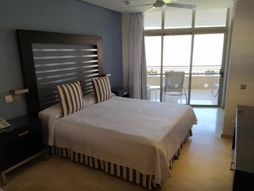 莫甘Anfi del Mar Tauro Golf 2 Emerald Club的一间卧室配有一张大床和两把椅子