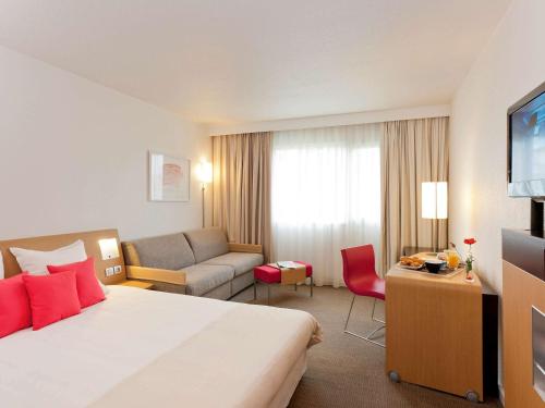 莱斯卡尔波城比利牛斯诺富特酒店的酒店客房,配有床和沙发