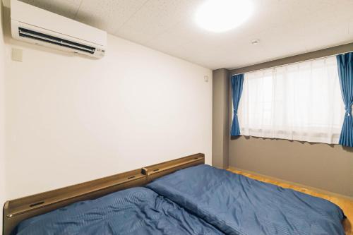 旭川STAY IN PASSION的一间卧室设有一张床和一个窗口