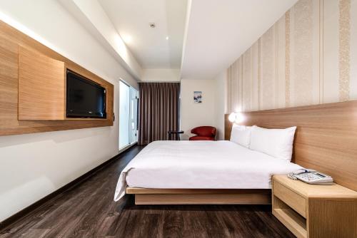 高雄鲔鱼家族饭店盐埕馆的一间酒店客房,配有一张床和一台电视
