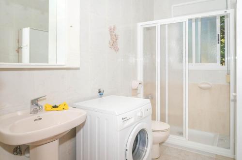 卡尔佩Bungalows Canadá Alquileres Vacacionales的白色的浴室设有洗衣机和水槽。
