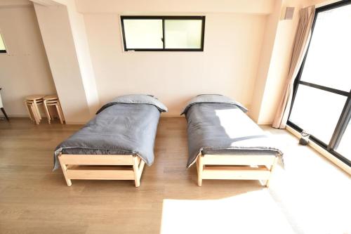 玉野市Enzo Uno的大型客房设有2张床和窗户。