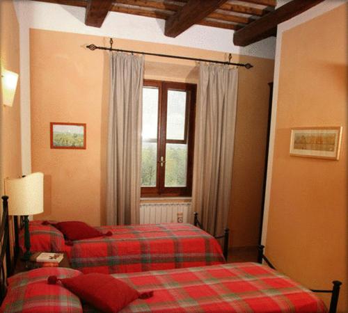 蒙塔尔托迪卡斯特罗特努塔萨拉考恩旅馆的一间卧室设有两张床和窗户。