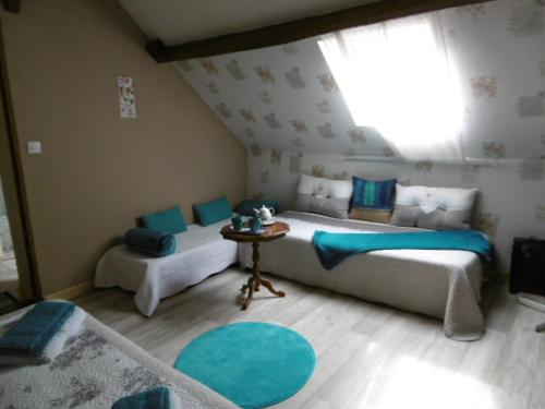 Saint-Julien-sur-CherChambres d'hotes du Moulin的一间卧室设有两张床、一张桌子和一个窗口