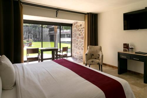 莱昂瑞奥米娜斯薄路瑞木酒店的酒店客房,设有床和滑动玻璃门