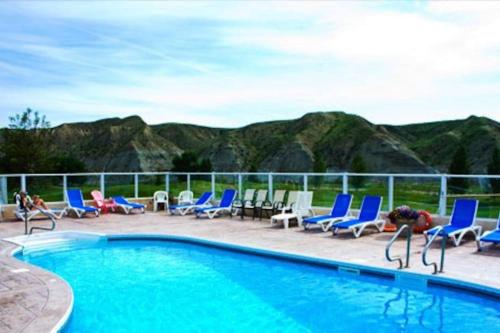 莱斯布里奇Paradise Canyon Golf Resort, Luxury Condo U409的一个带蓝色椅子的游泳池,背景是山脉