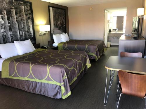 奥兰治堡Super 8 by Wyndham Orangeburg Near I-26的酒店客房设有两张床和一张桌子。