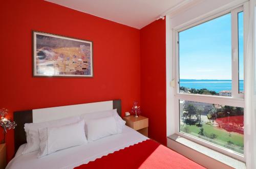 斯普利特Apartment Vana的红色卧室设有床和2扇窗户