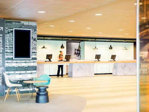 巴德胡弗多普阿姆斯特丹史基浦机场宜必思酒店的大堂设有桌子和椅子,