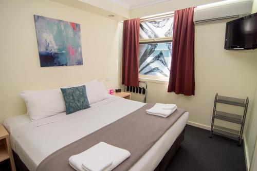 墨尔本墨尔本迈阿密酒店的一间卧室配有一张床,上面有两条毛巾