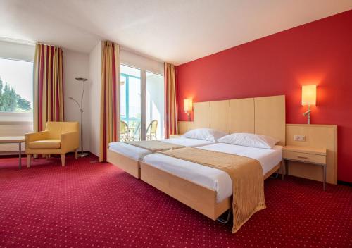 伊韦尔东Grand Hotel et Centre Thermal d'Yverdon-les-Bains的一间卧室设有一张大床和红色的墙壁