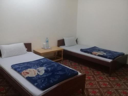Benazir Hotel Kalash的一间设有两张床和一张桌子的房间