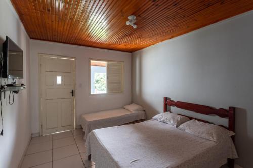 米格尔-佩雷拉Pousada Barão do Javary的一间卧室设有两张床和木制天花板