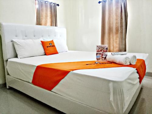 马贾伦卡WISMA ANDALI Syariah near RSUD Cideres的白色的床,配有橙色和白色的毯子
