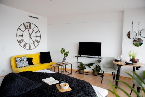 奥格斯堡Tolles Apartment mit Weitblick über Augsburg的客厅设有黄色沙发和电视