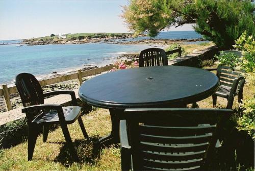 内维兹NEVEZ - MAISON LES PIEDS DANS L EAU avec vue imprenable的海滩旁的桌椅