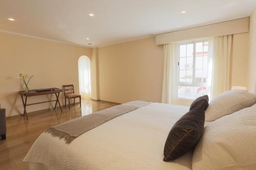 塞维利亚Epicenter的卧室配有一张大白色床和窗户