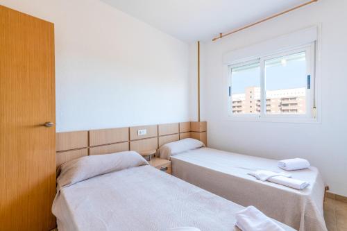 奥罗佩萨德尔马Vacaciones Oromarina Torremar的小型客房 - 带2张床和窗户