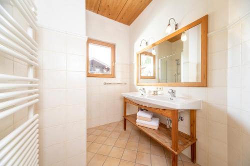 阿尔卑巴赫落叶松旅馆的一间带水槽和镜子的浴室