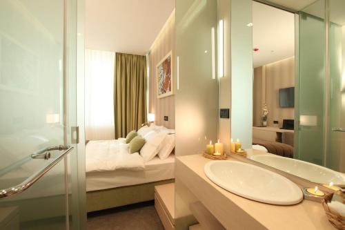 贝尔格莱德Hotel Argo的浴室设有床、水槽和镜子