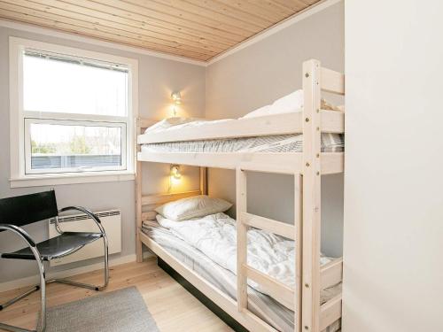 博托比Three-Bedroom Holiday home in Væggerløse 6的一间卧室配有双层床、书桌和椅子