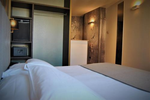 米兰莫肯巴国王酒店的卧室配有白色的床和电视。