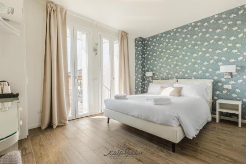 科拉迪拉齐塞CASA BACI - Soggiorno nel Gusto的卧室配有一张白色大床和花卉墙