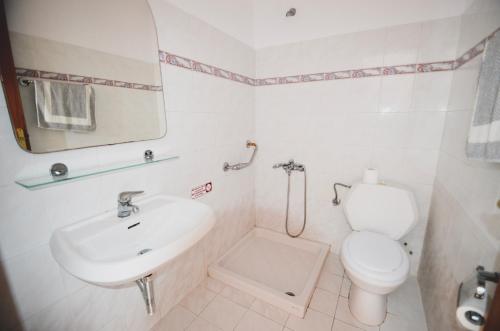 佩基罗德Coralli Apartments的白色的浴室设有卫生间和水槽。