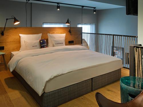 美因河畔法兰克福特瑞普25小时酒店的一间卧室配有一张大床和木制床头板