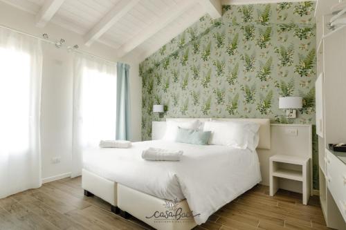 科拉迪拉齐塞CASA BACI - Soggiorno nel Gusto的卧室配有白色床和花卉壁纸
