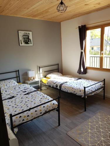 Saint-Amand-en-Puisayemaison indépendante的客房设有两张床和窗户。