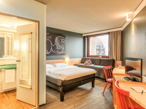 维也纳宜必思维也纳玛丽亚希尔费酒店的酒店客房,配有床和沙发