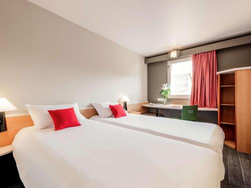卢尔德卢尔德中心咖利宜必思酒店的酒店客房 - 带两张大床和红色枕头