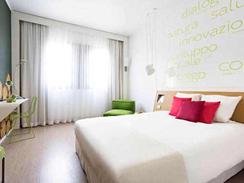 米兰诺富特米兰诺德卡格兰达酒店的卧室配有带红色枕头的大型白色床