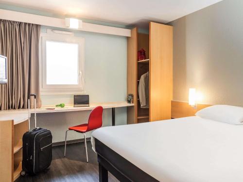 托农莱班ibis Thonon Centre的酒店客房,配有一张床和一张红色椅子