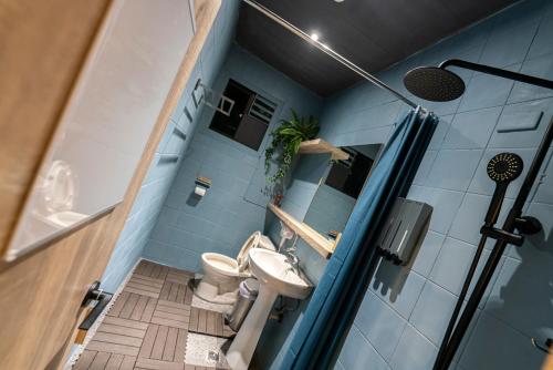 贡寮欧夫寇斯冒险青旅的蓝色的浴室设有卫生间和水槽