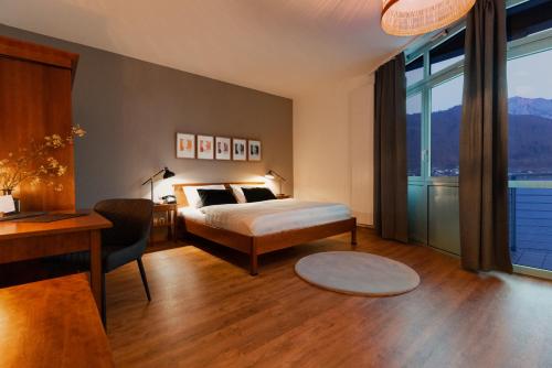 格蒙登Hotel Esplanade的一间卧室配有一张床、一张书桌和窗户。