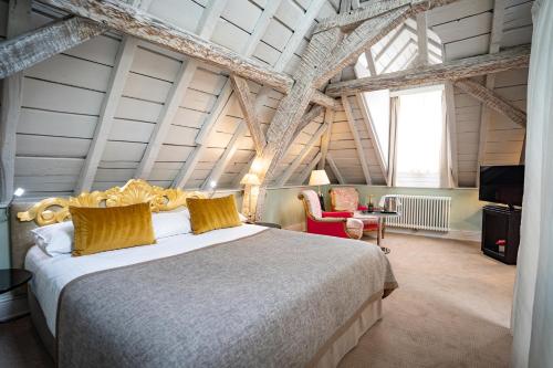 卢森堡Hotel Le Place d'Armes - Relais & Châteaux的卧室设有一张大床,卧室设有横梁