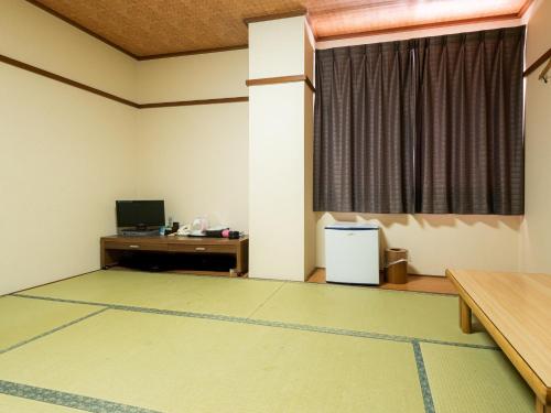 TakamiyaTabist Hotel Kurama Hikone的空房间,有书桌和窗户
