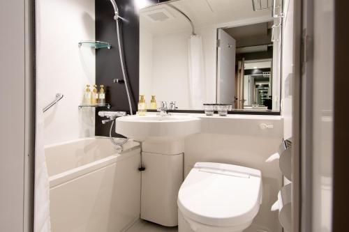 神户Kobe Plaza Hotel West的白色的浴室设有卫生间和水槽。