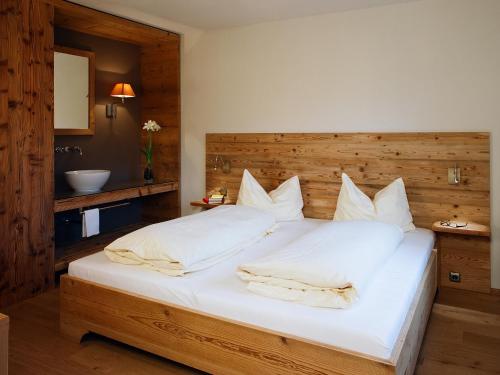 萨尔察赫河畔戈灵斯塔勒贺夫酒店的卧室配有一张白色大床和木制床头板