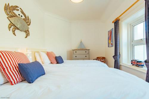 福克斯通Driftwood Cottage by Bloom Stays的一间卧室设有两张白色的床和窗户