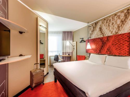 慕尼黑慕尼黑宜必思酒店的酒店客房配有一张大床和红地毯。