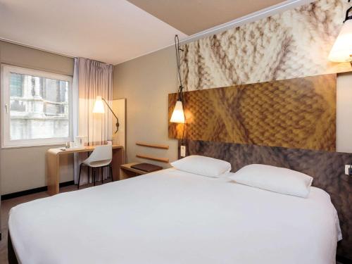 布鲁塞尔布鲁塞尔市中心宜必思酒店的酒店客房设有一张白色大床和一张书桌