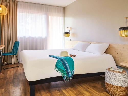 耶尔宜必思萨拉萨海耶若斯海滨酒店的酒店客房,配有一张白色的床,上面有帽子