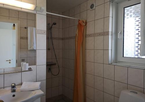 希茨海尔斯穆恩齐巴德酒店的浴室设有橙色淋浴帘和水槽
