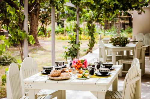 阿多Addo African Home的一张带食物和鲜花的白色桌子
